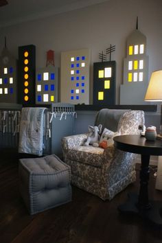 a living room filled with furniture next to a baby's crib and lamp