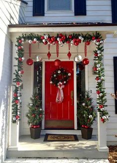 a red front door decorated with christmas decorations