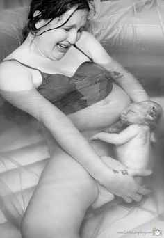 a woman in a bathing suit holding a baby