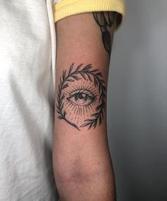 a person with a tattoo on their arm and an eye in the middle of it