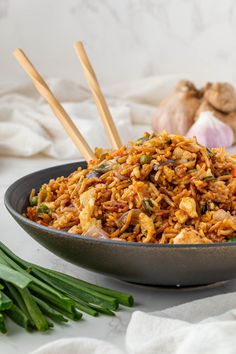 a bowl filled with rice and vegetables next to garlic