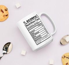 a coffee mug with nutrition information on it next to some cookies and spoons that are scattered around