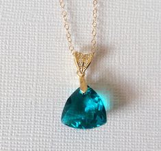 Blue Zircon Teal Triangle Crystal Gold Wedding Bridal Pendant Necklace with 14k Gold Filled Chain. PLEASE READ ITEM DESCRIPTION and SHOP POLICIES before placing your order, and contact me with any questions! CHAIN is 18 inches (45.7cm) long. PENDANT is about 0.90 inch (2.3cm) long including bail. BRIDAL NECKLACES SECTION: https://www.etsy.com/shop/LanaChayka?ref=seller-platform-mcnav§ion_id=11638944 JEWELRY SETS SECTION: https://www.etsy.com/shop/LanaChayka?ref=seller-platform-mcnav§ion_id=18873488 BRIDAL JEWELRY SETS SECTION: https://www.etsy.com/shop/LanaChayka?ref=seller-platform-mcnav§ion_id=25839214 Elegant and timeless, this beautiful necklace is perfect for weddings or special occasions such as birthdays, anniversaries, graduations, proms...or whatever you can imagine! Handmade neck Affordable Blue Crystal Necklace Gift, Unique Blue Crystal Necklace For Gift, Blue Crystal Pendant Necklaces, Blue Teardrop Crystal Necklace For Gifts, Bridal Pendant Necklace, Elegant Blue Crystal Pendant Necklace, Wedding Peacock, Bridal Necklaces, Teal Jewelry