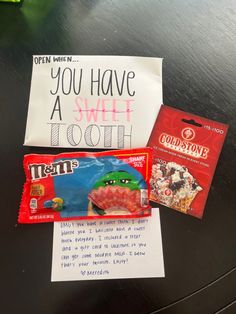 some candy is sitting on a table next to a note that says, you have a sweet tooth