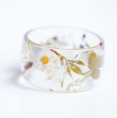 Floral bangle is made with handpicked dried flowers from Lithuania fields. Botanical jewelry is unique handmade product, each peace will be slightly different from photo. Each bracelet is handmade OOAK jewelry. I use only natural flowers and plants, no paints are added. Resin bangle is light and transparent. Lovely gift idea for nature lovers.  Chunky bangle - totally handmade clear resin bracelet. Made with natural white flowers! XS/S size bracelet:   - External diameter 7 cm   - Internal diame Handmade Clear Bracelets As Gifts, Handmade Clear Bracelets As A Gift, Handmade Clear Bracelets For Gifts, Nature-inspired Cuff Bangle Bracelet For Gifting, Nature-inspired Bangle Cuff Bracelet As Gift, Nature-inspired Cuff Bangle Bracelet As Gift, Handmade Resin Bangle, Botanical Resin Jewelry With Natural Inclusions, Handmade Nature-inspired Bangle As Gift