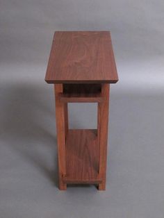 a small wooden table sitting on top of a gray floor