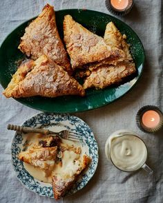 some food is sitting on a plate next to candles and cups with sauces in them