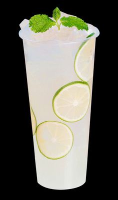 a drink with lime slices and mint on the rim