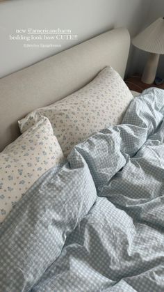 an unmade bed with blue and white checkered sheets