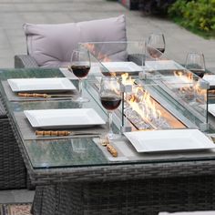 a table set with wine glasses, plates and utensils on top of it