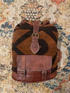 Mudcloth is fabric that is dyed with fermented mud then hand painted with the mud to create the different designs you see. This backpack is paired with Mudcloth from Mali and durable leather. Bohemian Brown Standard Backpack, Bohemian Style Brown Backpack, Artisan Brown Backpack For Travel, Artisan Brown Backpack Shoulder Bag, Artisan Backpack For Travel, Artisan Travel Backpack, Artisan Backpack For Daily Use, Handmade Brown Travel Backpack, Brown Leather Patch Backpack