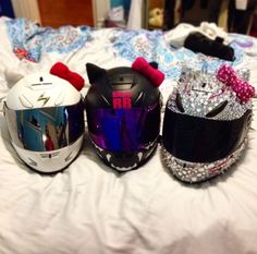 three helmets are lined up on a bed