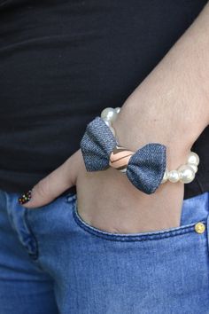 a close up of a person wearing a bow tie bracelet