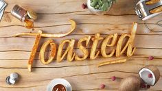 the word toasted spelled out in cursive font surrounded by other food items