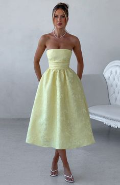 A dress to wear all seasons, Saoirse in Lemon is cut from our prettiest floral jacquard fabric in a midi length with super full skirt lined with tulle for extra volume. This strapless style has boning in the bodice for a cinched waist, with pleating and gathered detailing. The look is complete with lace up back. Wear with a pointed heel and chic hair up.Ã‚Â 



Colour: Lemon.

Floral jacquard fabric.

Fully lined.

Full skirt with tulle for volume.

Pleated bodice.

Boning in bodice.

Gathered d Luxury Spring A-line Midi Dress, Luxury Spring Dress With Gathered Neckline, Luxury Satin Midi Dress For Garden Party, Luxury Pleated Sleeve Dress For Garden Party, Luxury Chic Pleated Strapless Dress, Luxury Chic Puff Sleeve Dresses, Luxury Fit And Flare Dress With Ruffles, Luxury Romantic Midi Dress With Sweetheart Neckline, Luxury Short Sleeve Dress With Gathered Waist