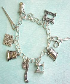 a silver charm bracelet with sewing accessories on it