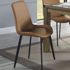 a dining room table with two chairs and a rug on the floor next to it