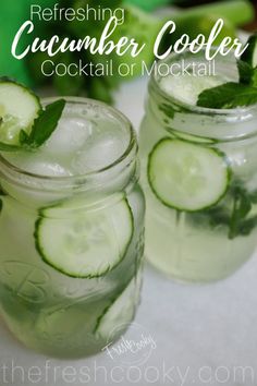 two mason jars filled with cucumber cooler cocktails on top of a table