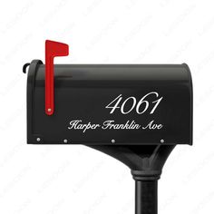 a black mailbox with the number forty four on it and red handle is in front of a white background