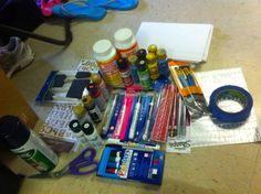 the desk is cluttered with pens, pencils, markers, and other items