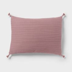 a pink pillow with tasselled edges