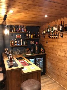 a bar with stools and shelves filled with liquor bottles