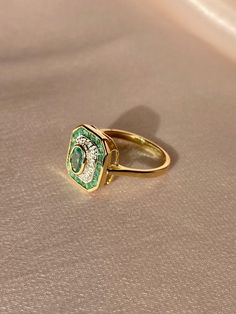 Gorgeous 9k yellow gold emerald and diamond deco style target ring. This vintage inspired piece features 4 small round cut diamonds and 19 oval + round cut emeralds. The emeralds have natural inclusions and carbon spots and range in color. The very small diamonds are set in an illusion-type setting: north, south, east and west.Weight: ~ 3 gramsHallmarks: 375 for 9k, anchor for Birmingham EnglandHead of the ring: 12.75 mm x 11.75 mmEmerald: 5.5 mm x 3.5 mm oval cut natural (central), 18 x 2 mm na Target Ring, Art Deco Rings, Art Deco Emerald Ring, Tiny Diamond, Deco Ring, North South, To Infinity And Beyond, Type Setting, Dream Jewelry