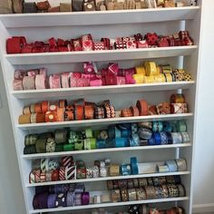 a shelf filled with lots of different types of ribbons on top of white shelving