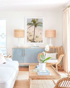 a living room with wicker furniture and palm trees on the wall behind it,