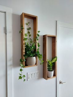 two wooden boxes with plants in them are hanging on the wall next to a door