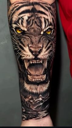 a man with a tiger tattoo on his arm and hand, showing it's teeth