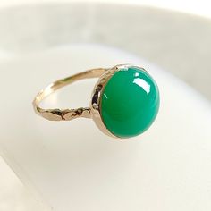 TEM DESCRIPTION: >> The Ring is made from Solid 14K Yellow Gold. Gemstone used is absolutely natural and ethically sourced.  >> Natural Chrysoprase in cabhachon cut and round shape with bezel setting is studded on it with utmost precision.  >>Gem: Chrysoprase Gem size: 12×12 mm, round Gem weight: 7.40 carats Gold purity: 14K (58.33% approx.) Gold weight: 1.52 grams Gross weight : 3.00 grams The Gold purity is guaranteed and it comes with authentic 14K gold hallmark. Since these Rings are handmad Yellow Gold Emerald Chrysoprase Cabochon Ring, Heirloom Green Jade Rings, Green Opal Birthstone Ring In 14k Gold, Yellow Gold Chrysoprase Cabochon Ring, Yellow Gold Rings With Chrysoprase Gemstone, Oval Green Chalcedony Rings, Green Oval Chalcedony Rings, Heirloom Green Opal Round Ring, Heirloom Green Opal Ring