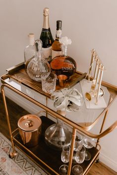 a bar cart with bottles and glasses on it