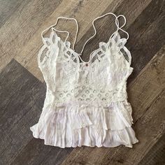 Intimately Free People Adella Cami Top In White New With Tags Size Medium Favorite-Ever Bralette, Now As A Cami Featuring A Flowy, Tiered Design To Complement The Intricate Crochet Lace Top. Crisscross Straps A-Line Silhouette Lined Bust White Beach Camisole With Built-in Bra, White Lace Top With Built-in Bra For Summer, Summer Sleeveless Lace Top, Bra Friendly, Summer Sleeveless Bra-friendly Lace Top, White Camisole With Delicate Straps For Vacation, White Vacation Tops With Delicate Straps, White Delicate Straps Camisole For Vacation, White Crochet Lace Camisole Top, White Ruffled Camisole For Beach