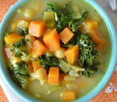 a bowl of soup with carrots, kale and broccoli