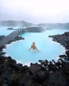 a woman sitting in the middle of a blue lagoon