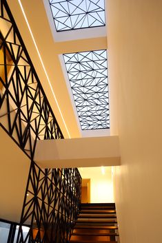 the ceiling is made up of metal and has a glass skylight above it, along with wooden stairs