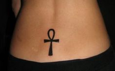 an egyptian cross tattoo on the back of a woman's lower body is shown