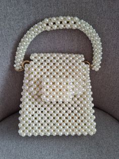 This luxurious beaded evening bag is handmade Bag made of round beads  color white The versatile color will complement any outfit. Bead size 8*6 mm,  In the work, a fishing line 0.6 mm thick was used The fishing line provides a tight frame. The fishing line can withstand about 10 kg GOLD coloured hardware There is a button on the lid. There is a long handle 120 cm , gold colour, material stainless steel The chain can be removed if desired The bag can be carried in hand or over the shoulder. The bag holds a mobile phone, money, cosmetics, keys, wallet The bag is perfect for every day, as well as for a date, a wedding Every girl will be happy with such a gift. ! Product color may vary depending on screen settings.! Bag size Length 17 cm Width 7 cm Height 16 cm height wiht beaded handle - 30 Handmade Pearl Handheld Evening Bag, Handmade Pearl White Evening Bag For Events, White Beaded Evening Bag For Events, White Handheld Evening Bag With Pearl Embroidery, Handmade Pearl Evening Bag In Cream, Handheld White Pearl Evening Bag, Handheld Pearl Evening Bag Handmade, White Evening Bag With Pearl Handle, White Beaded Handheld Evening Bag