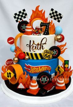 a birthday cake is decorated with cars and flames