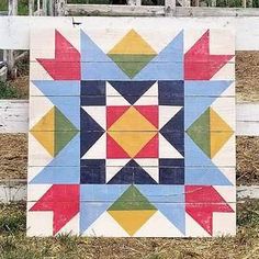 a wooden fence with a colorful quilt on it