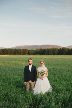 a bride and groom standing in the middle of a field