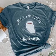 "Looking for a funny and cute Shark Shirt that's perfect for Shark Week or a Shark-themed birthday party? Look no further than our \"Sorry if I am a Little Shark-astic\" T-Shirt! This sea-inspired tee is the perfect gift for any Shark-astic lover, and it's sure to make a splash wherever you wear it. So why wait? Order your Shark T-Shirt today and show off your love for all things shark-related! **The design is made to look \"vintage\" faded and will look slightly opaque to give that well-worn retro feel. ★ 100% Soft cotton (fibre content may vary for different colors) ★ Runs true to size * Unisex t shirt fits like a well-loved favorite, featuring a crew neck, short sleeves and designed with superior airlume combed and ring-spun cotton that acts as the best blank canvas for printing. * Feat Funny Shark, Shark Themed Birthday Party, Sea Gifts, Sharks Funny, Shark Themed, Shark Shirt, Aunt Shirts, Cute Shark, Shark T Shirt