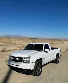 a white truck is parked in the desert