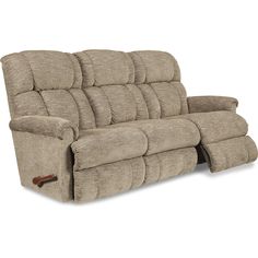 the power reclining sofa is shown in light brown fabric and has two pillows on it