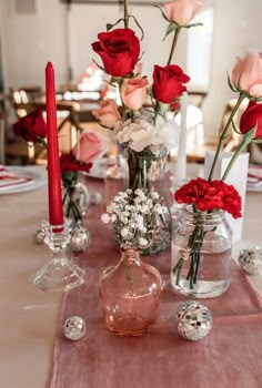 a table topped with vases filled with red and white flowers