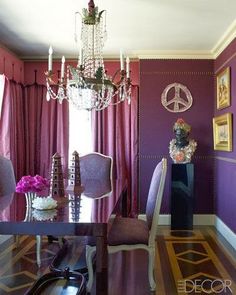 an elegant dining room with purple walls and chandelier