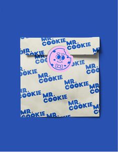 a paper bag with a cookie monster sticker on it's side and blue background