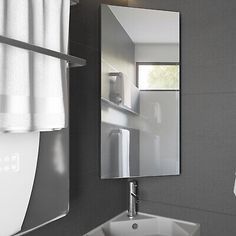 a white sink sitting under a bathroom mirror next to a towel dispenser