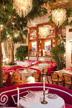 the interior of a fancy restaurant with chandeliers hanging from the ceiling and red booths